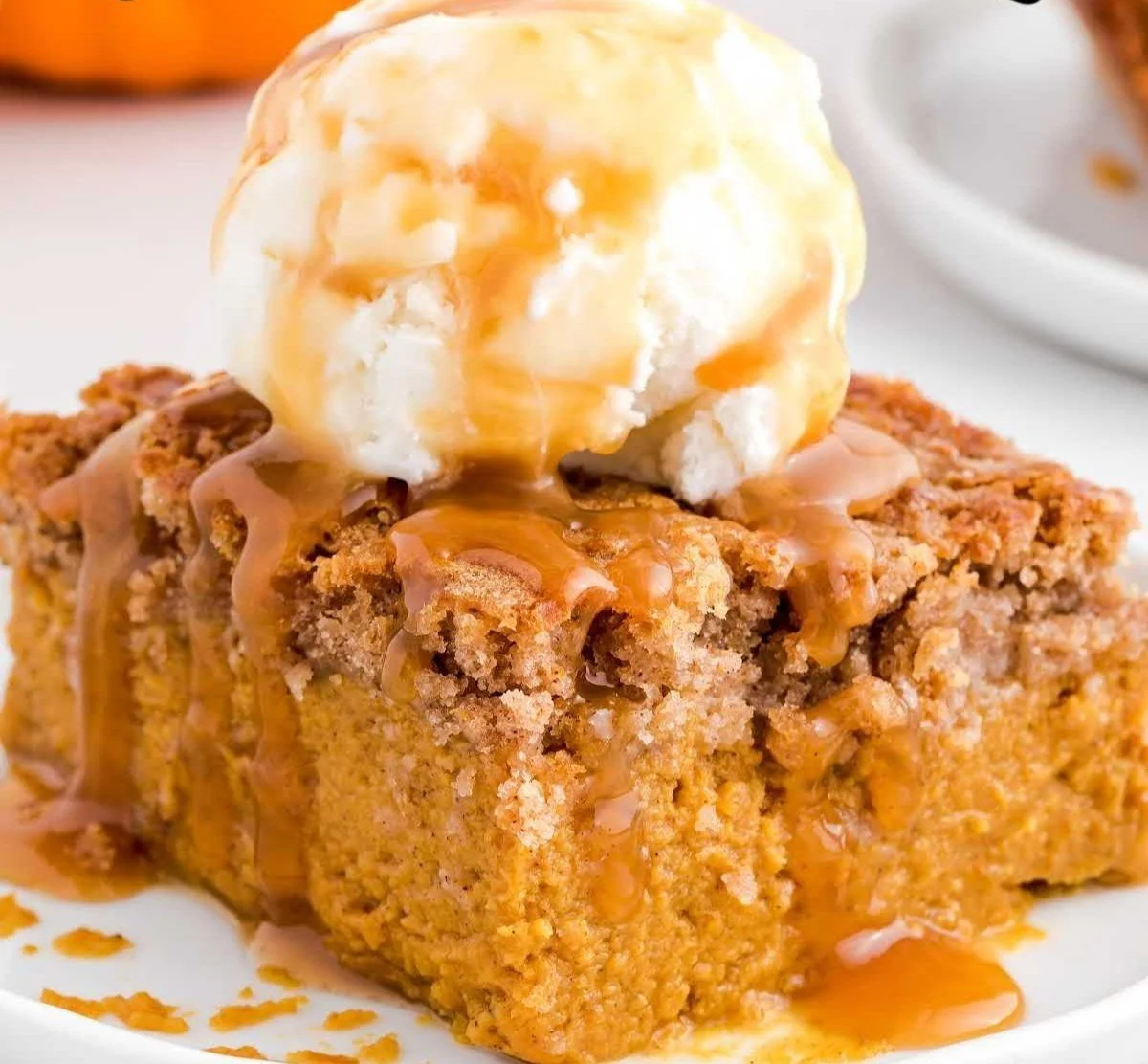 Delicious pumpkin spice dump cake topped with whipped cream and cinnamon