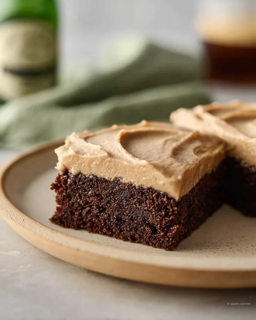 Delicious Guinness brownies with creamy frosting on top served on a plate.
